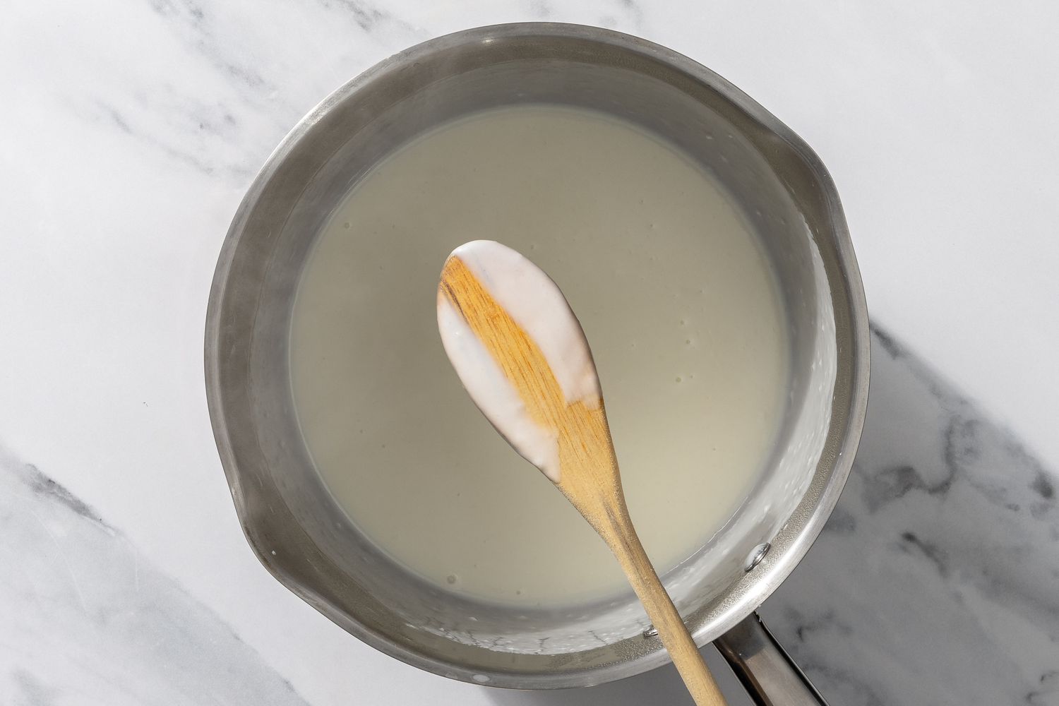 creamy mixture in a pot, wooden spoon coated for My Mom’s Famous Broccoli Cheese Casserole