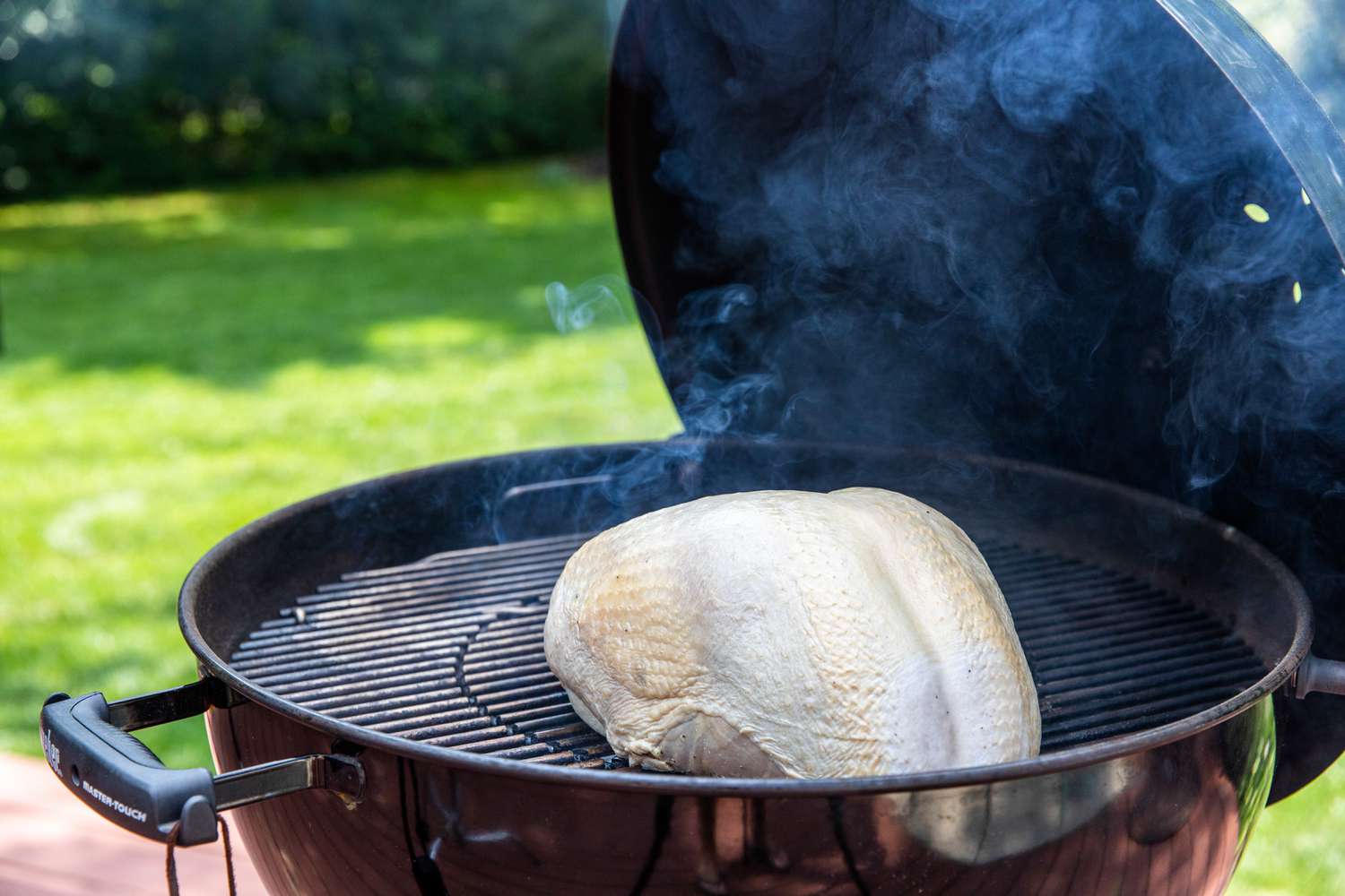 Smoking a turkey breast on a grill.