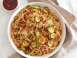 Large bowl of spicy noodles with cucumbers and chili crisp.