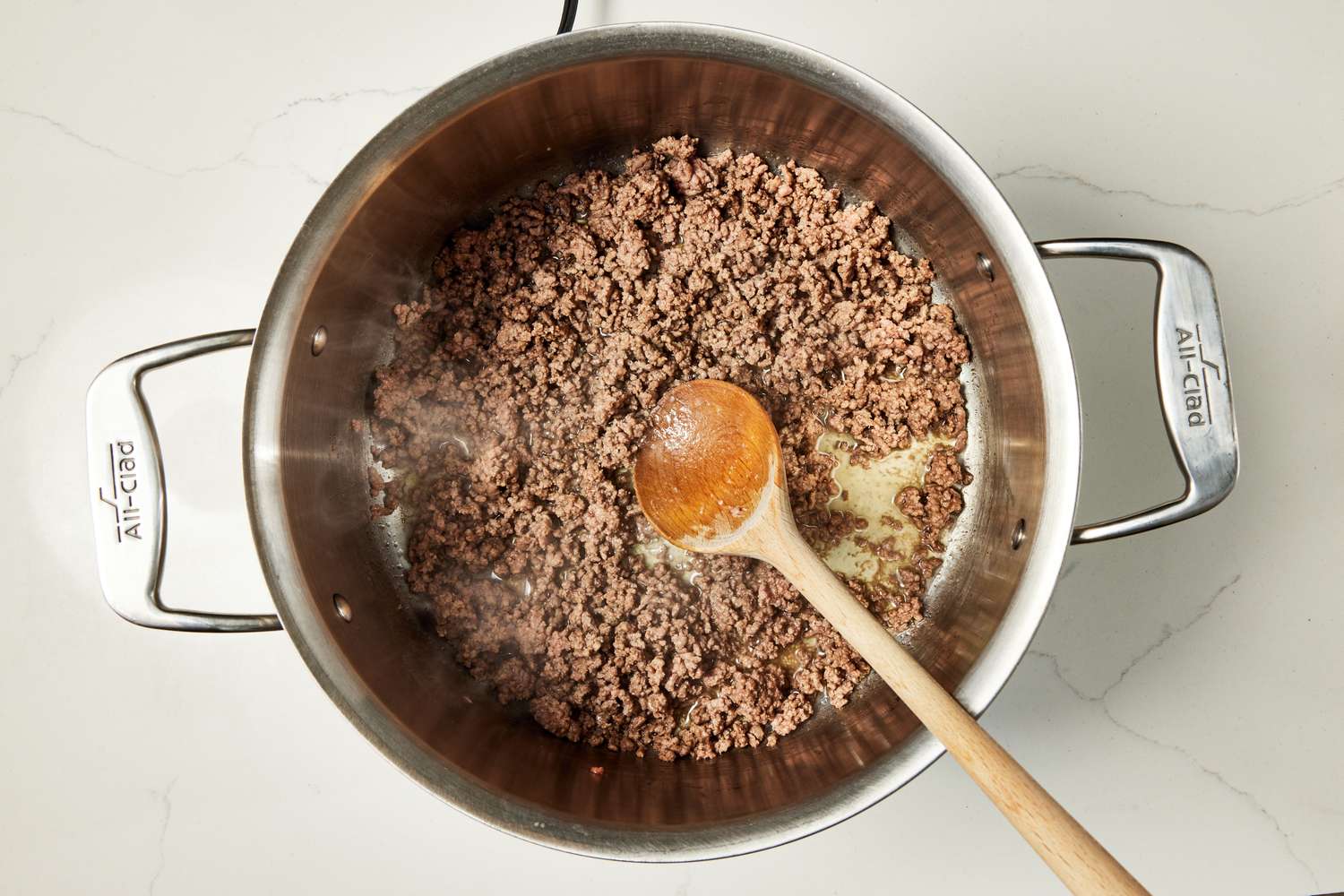 Browned beef broken into smaller pieces using a spoon (in a pot) for copycat Wendy's chili recipe