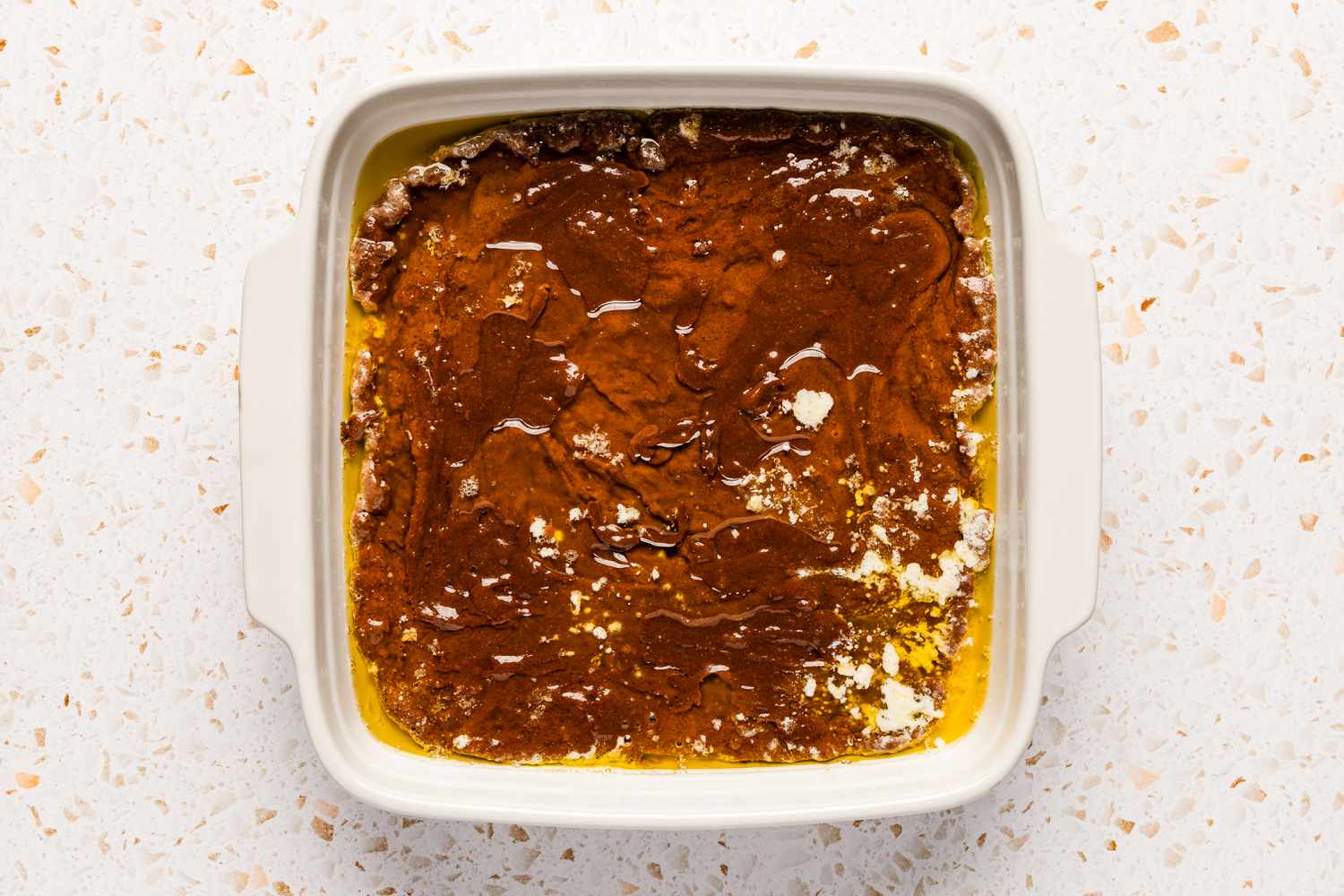 Batter poured into square baking dish for southern chocolate cobbler recipe