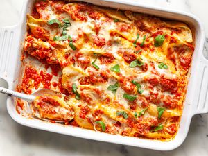 Stuffed Shells in a Casserole Dish with Some on a Serving Spoon