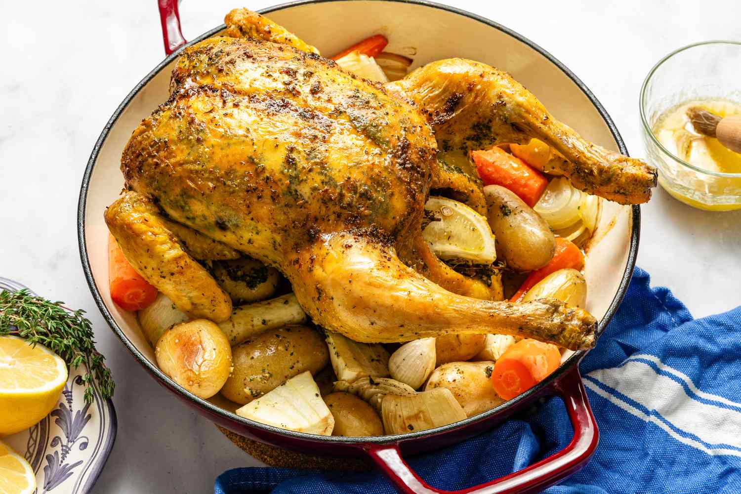 Roast chicken in a pan with vegetables like potatoes and carrots