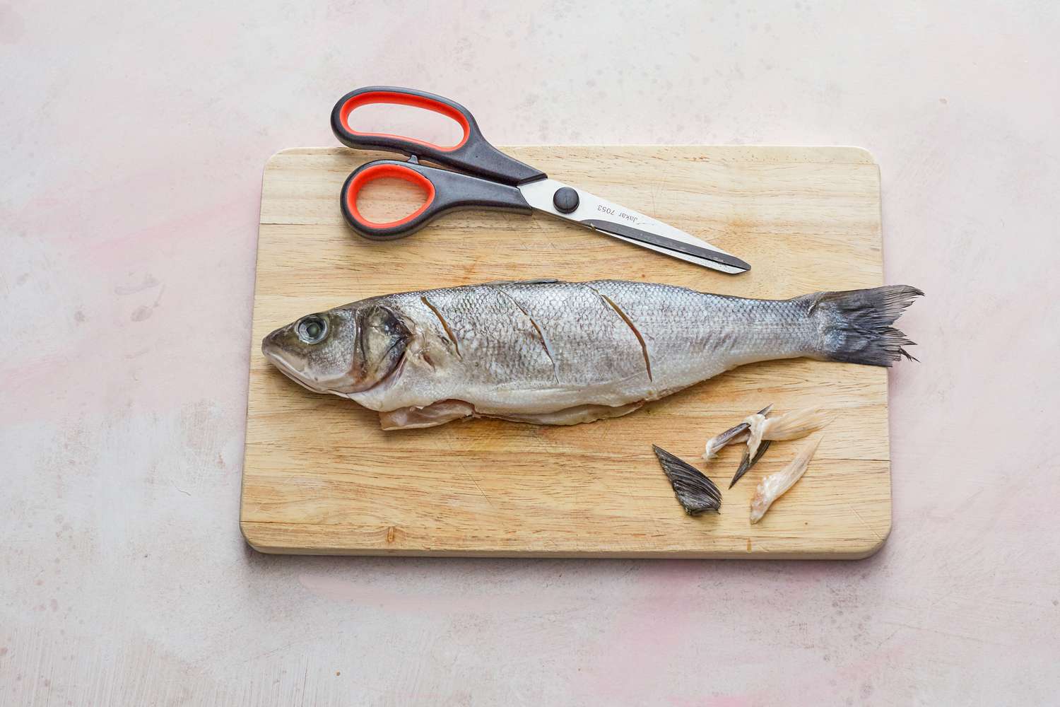 Prepping the whole fish set on a cutting board.