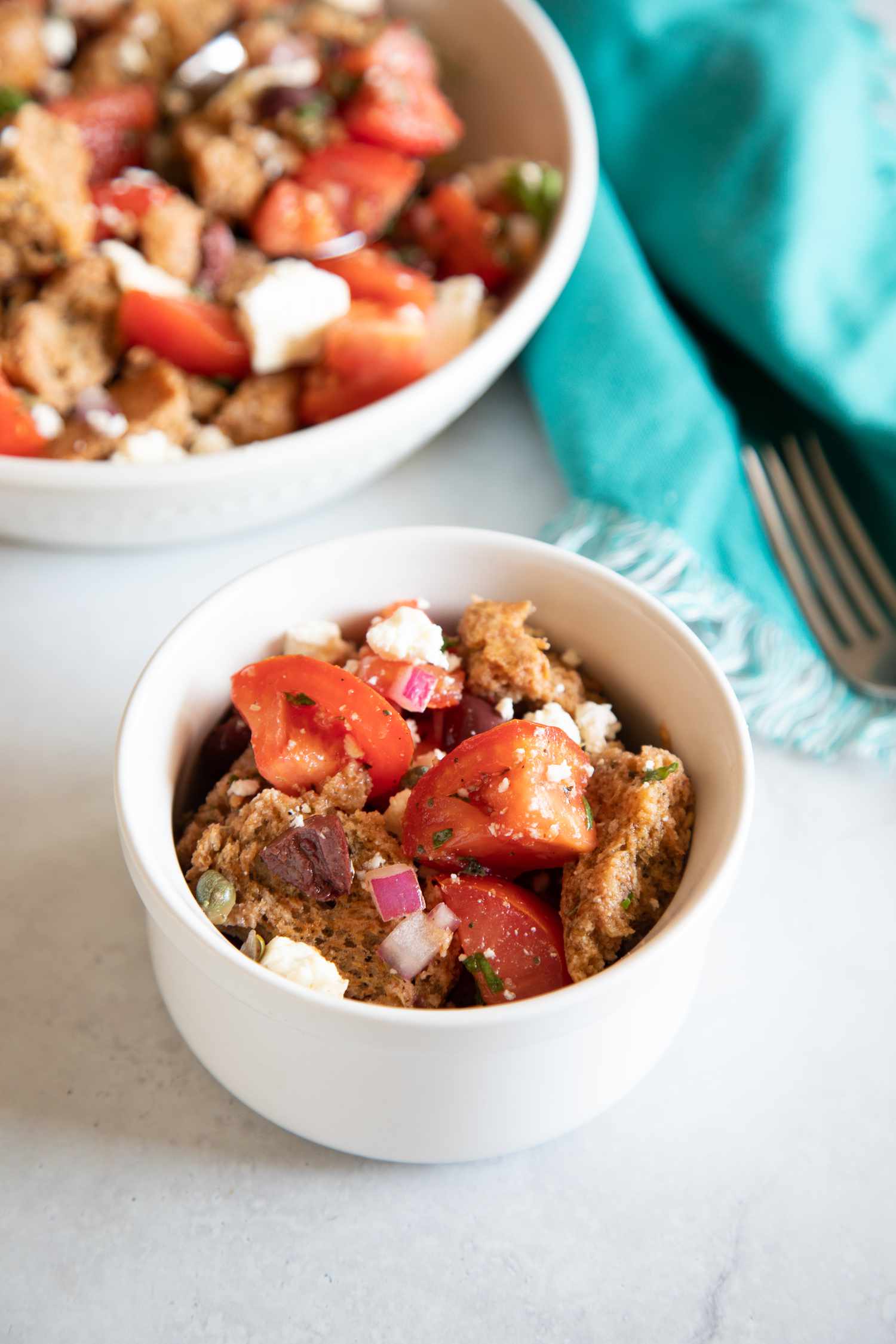 Mediterranean Greek salad in a bowl with a serving bowl of salad behind it.