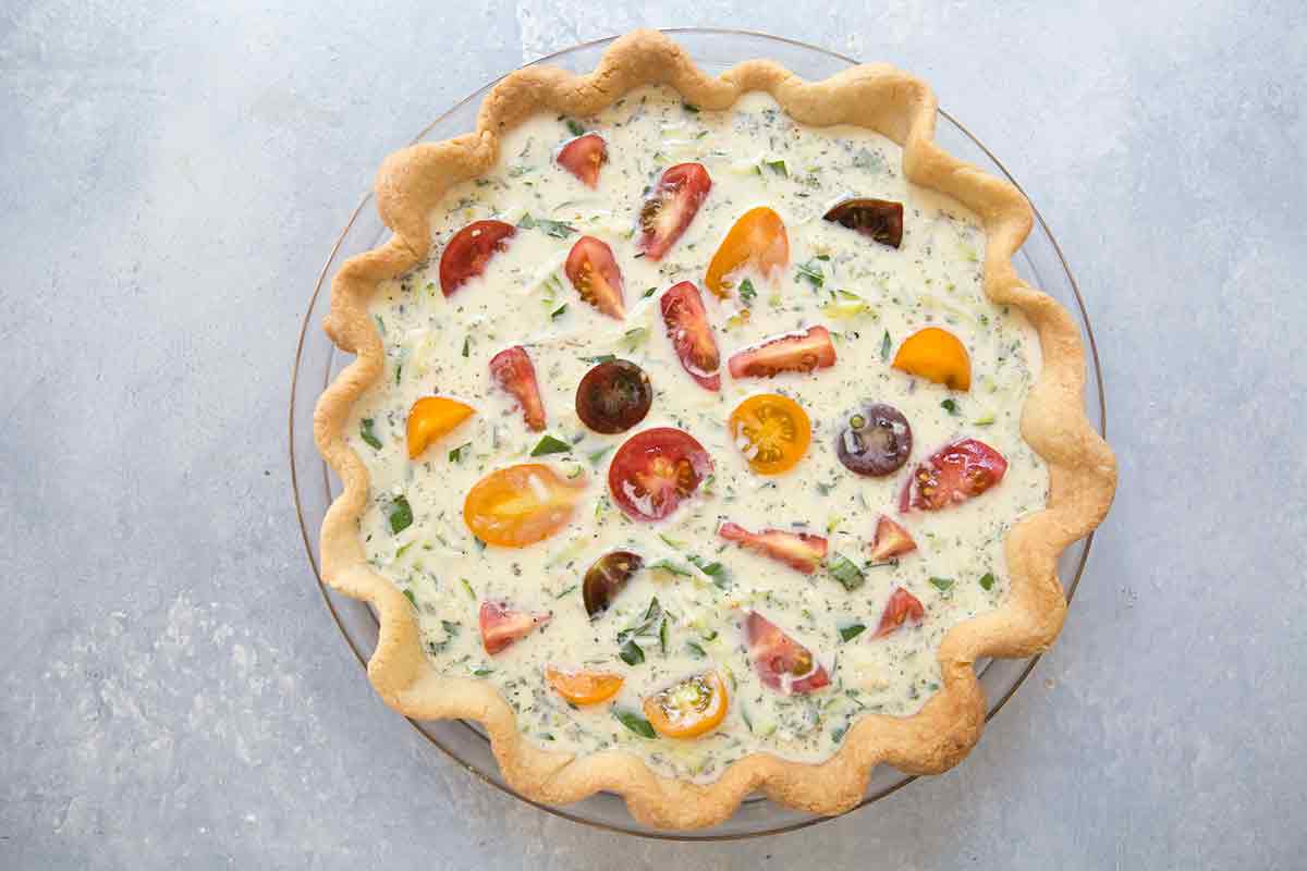 Zucchini and tomato quiche add the quiche filling, top with cut cherry tomatoes