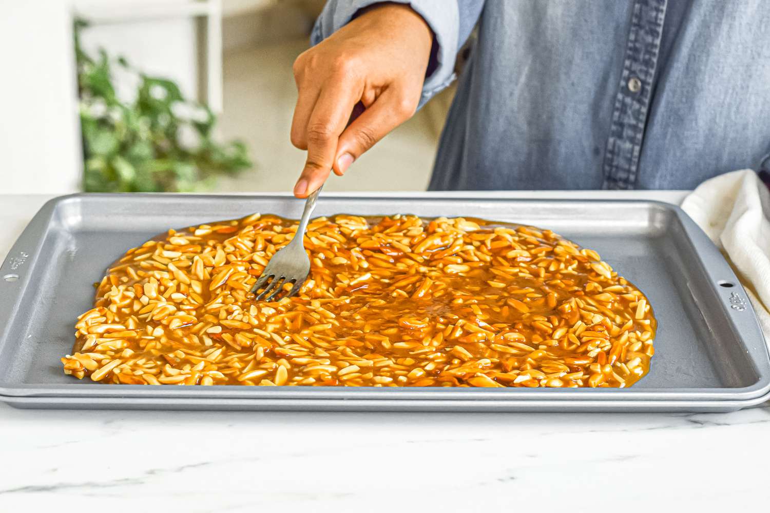 Spreading almond roca on a baking sheet.