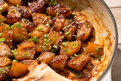Glazed potato dish garnished with green onions