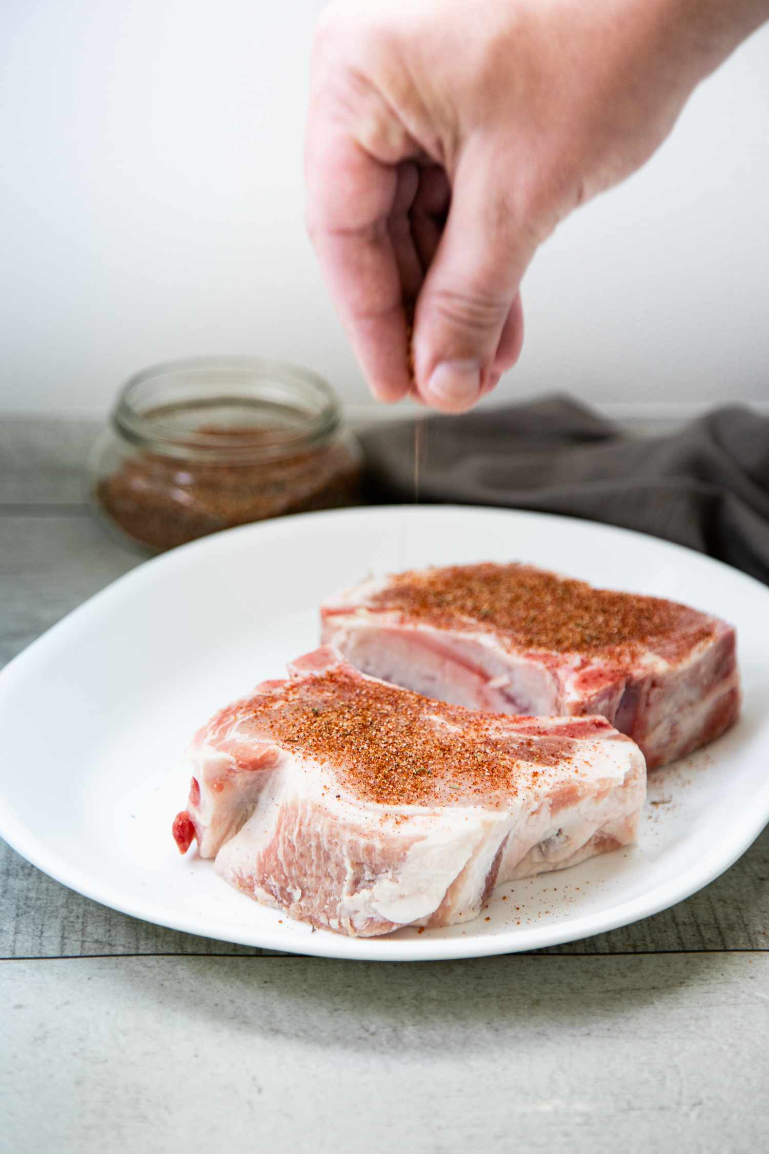 Hand Seasoning a Pork Chop