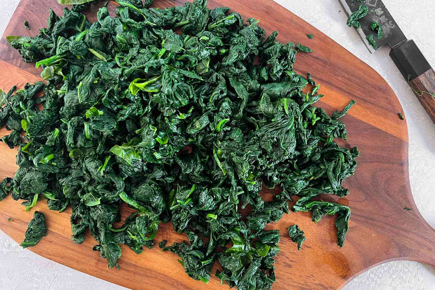 Wilted Spinach Cut into Smaller Pieces on a Cutting Board