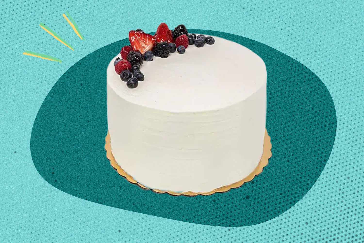 A simple white cake topped with assorted berries, placed on a teal background with a yellow accent