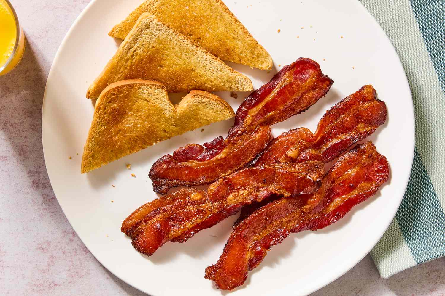 Plate with cooked bacon and toasted bread slices