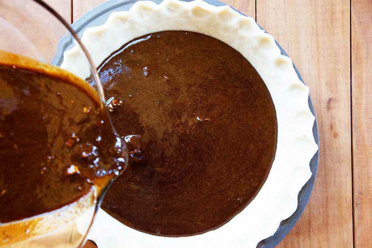 How to make shoo fly pie by pouring the dark molasses filling into an unbaked pie crust.
