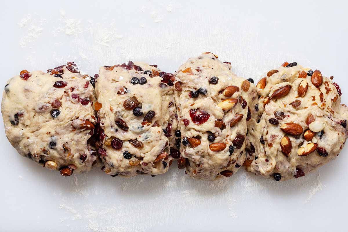 Stollen Christmas Bread dough filled with rum-soaked dried fruit and cut into four equal portions.
