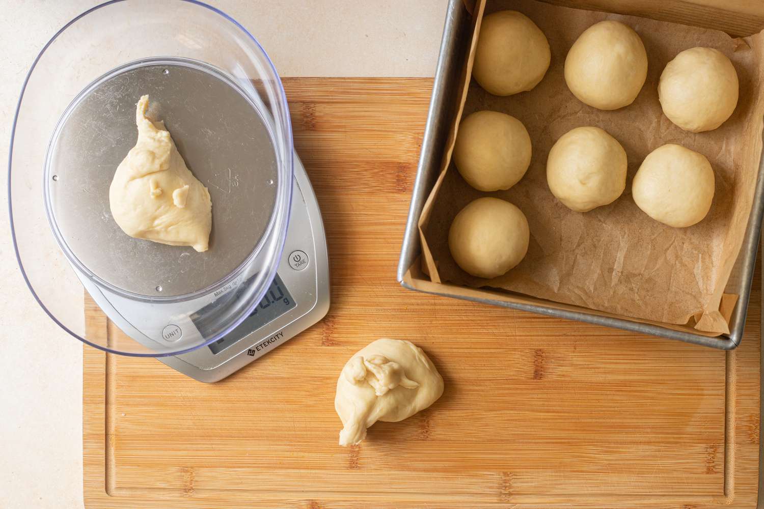 Rolling dough into balls using a scale.