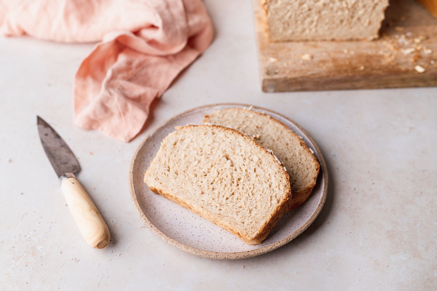 Homemade oatmeal bread slices on a plate.