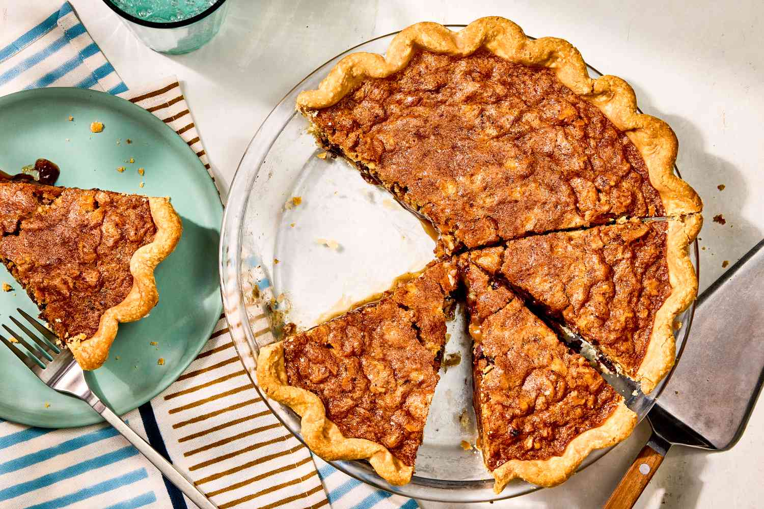 overhead view of Kentucky Derby Pie, slices cut, one on a plate with a fork