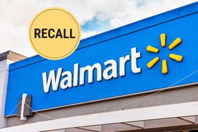 Walmart logo on storefront with a circular recall symbol in the corner
