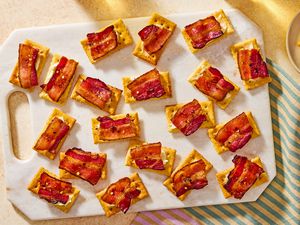 Overhead view of a serving board of millionaire crackers appetizer on top of a striped cloth napkin