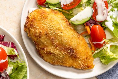 Overhead view of a plate with a ranch baked chicken breast and salad