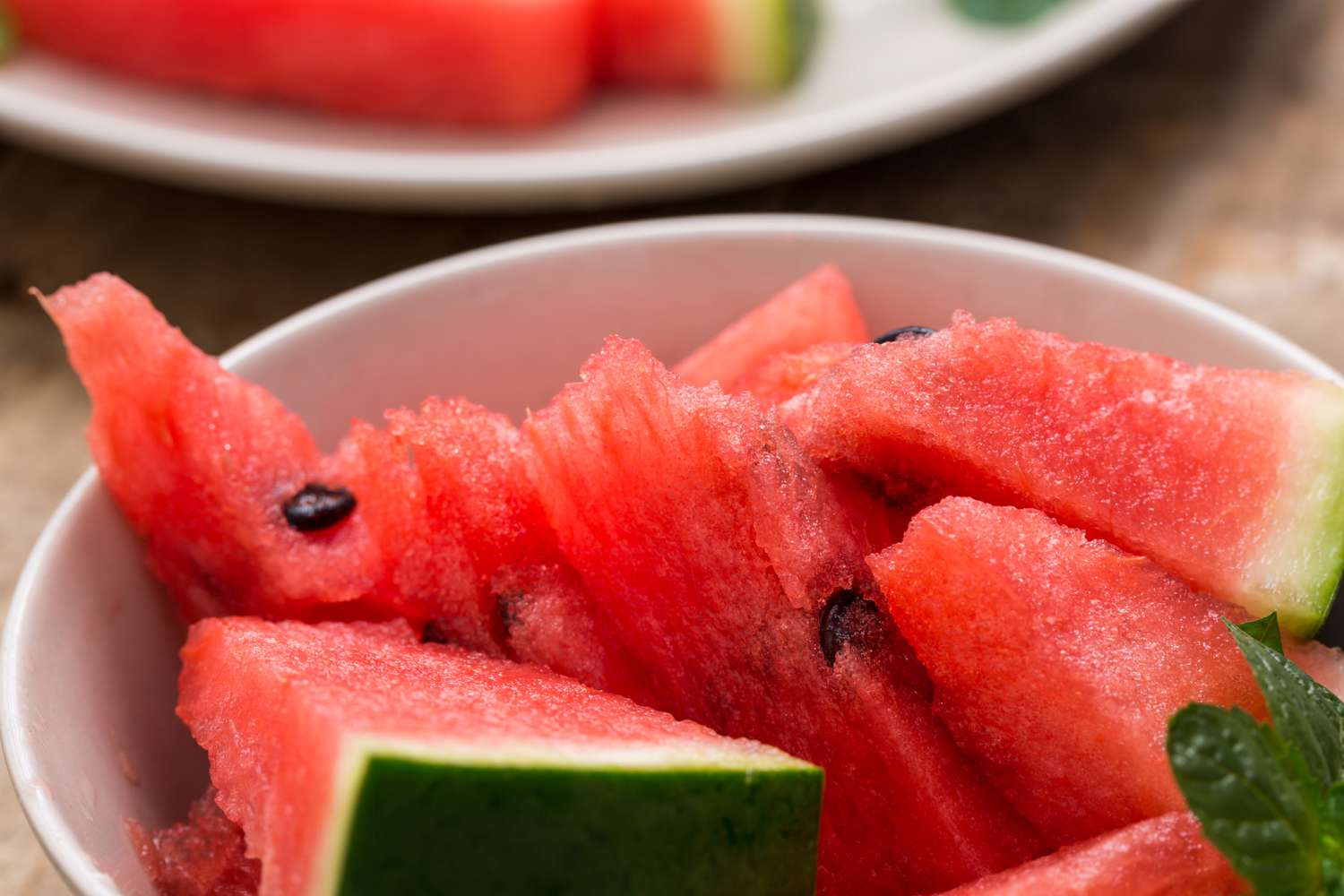 Bowl of cut watermelon wedges with rind and seeds