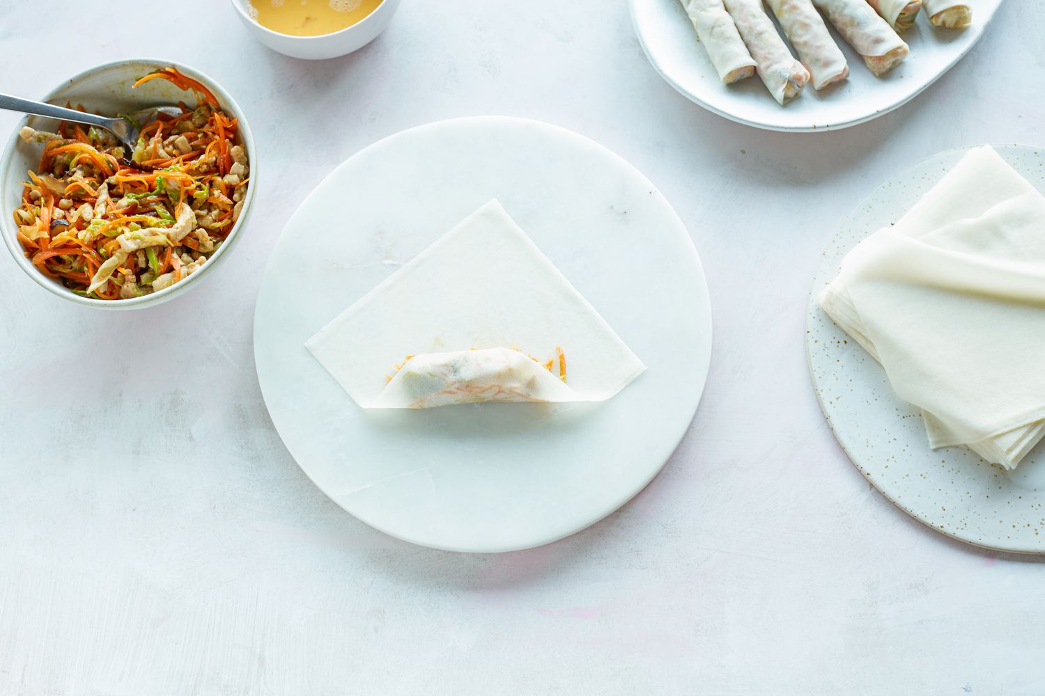 Rolling filling in wrapper to make fried spring rolls.