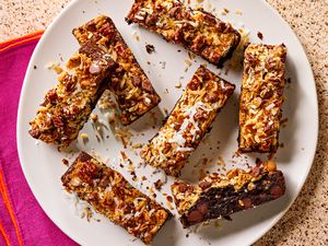 Overhead view of hello dolly brownie bars on a white plate on a brown countertop