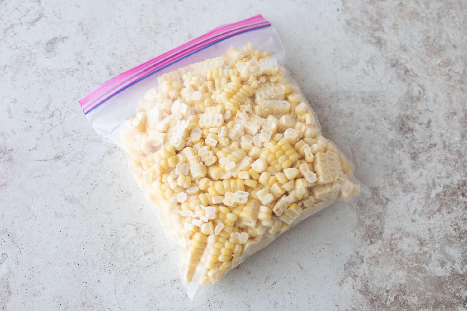 Corn kernels in a plastic bag on a grey countertop