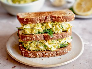 Side view of a triple decker sandwich made from mayo-free egg salad on a small plate
