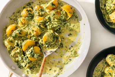 large platter of 5-Ingredient Curried Potatoes with a serving spoon and two bowls on the side