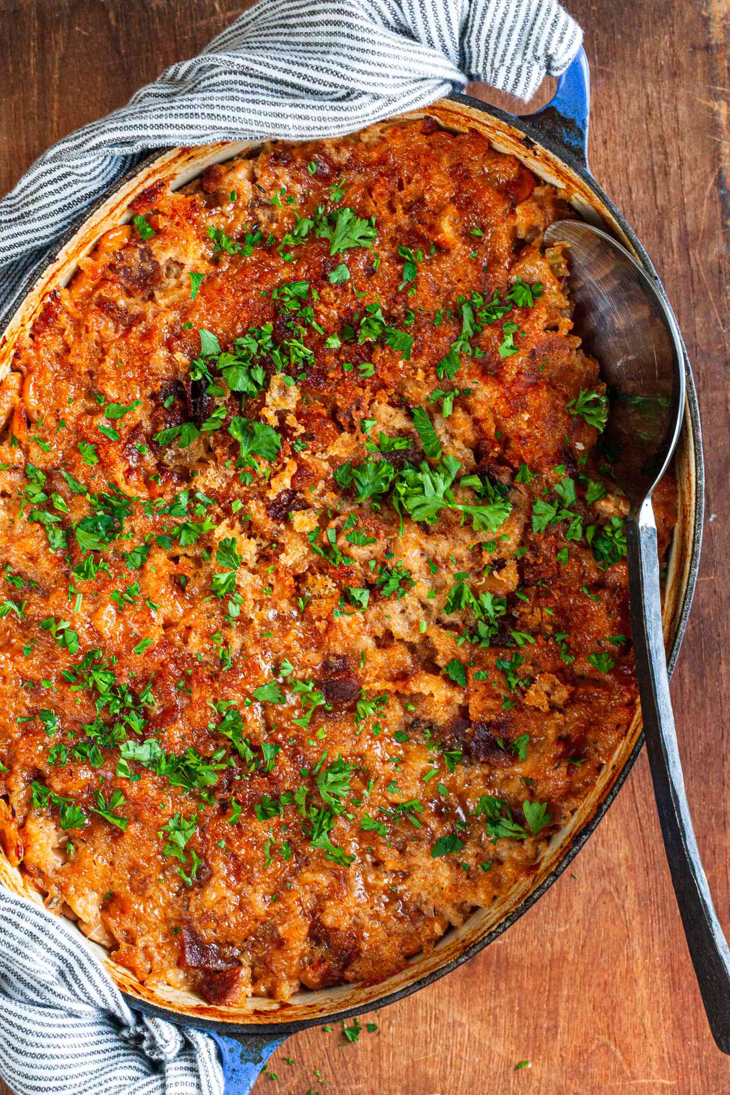 Cassoulet in Dutch oven with large spoon.