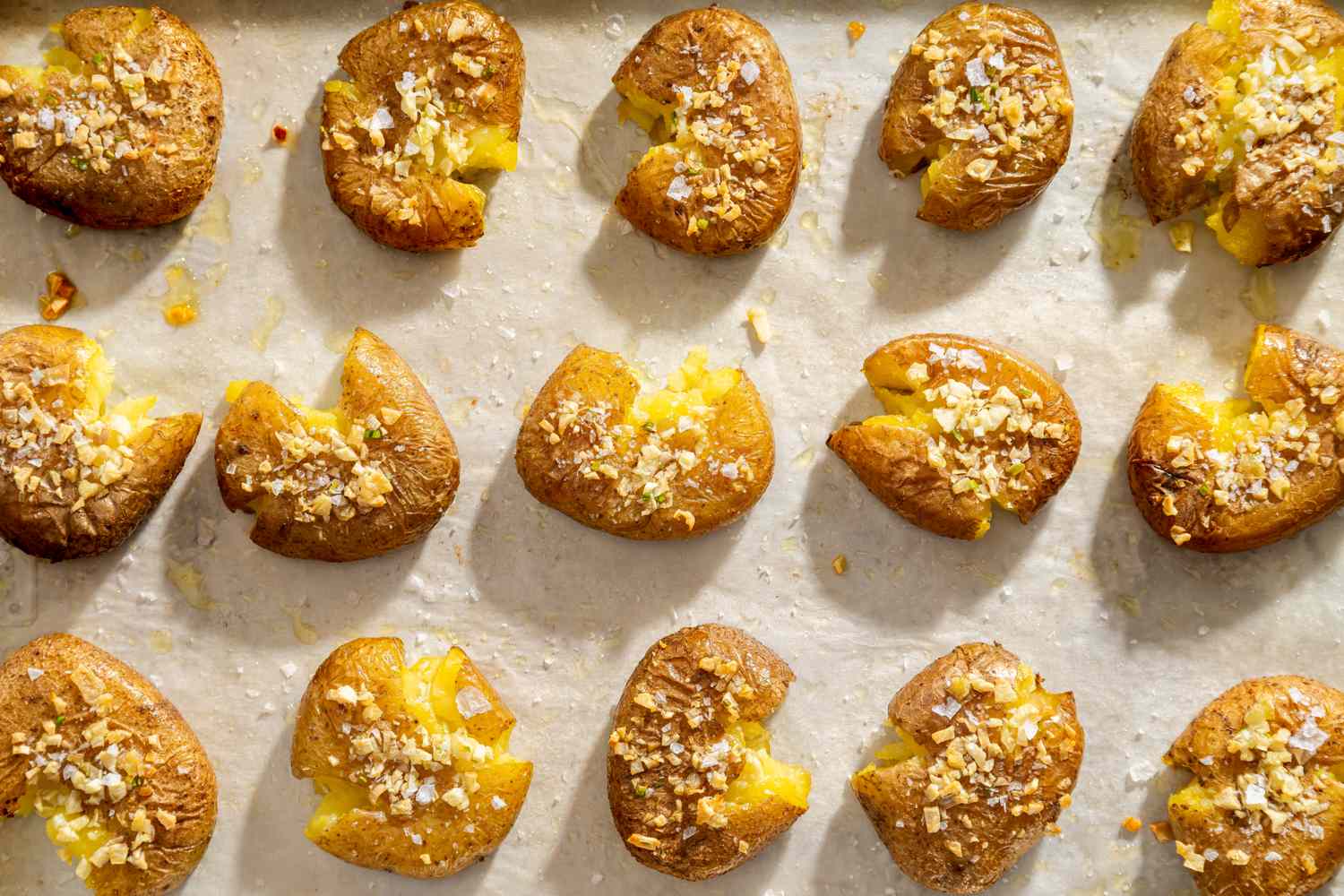 Tray of smashed roasted potatoes topped with seasoning and baked until crispy