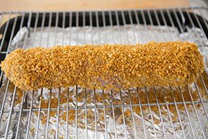 panko crusted pork tenderloin on rack to bake in oven