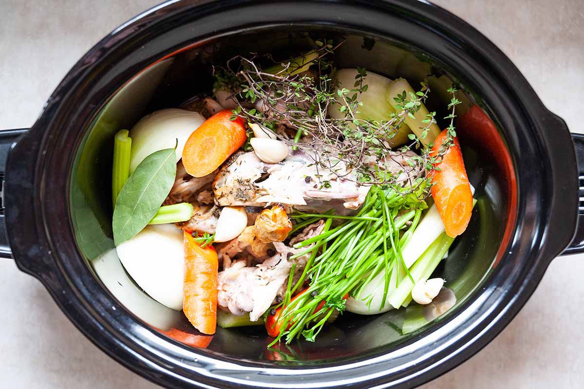 How to Make Chicken Stock in the Slow Cooker combine the veggies in the slow cooker