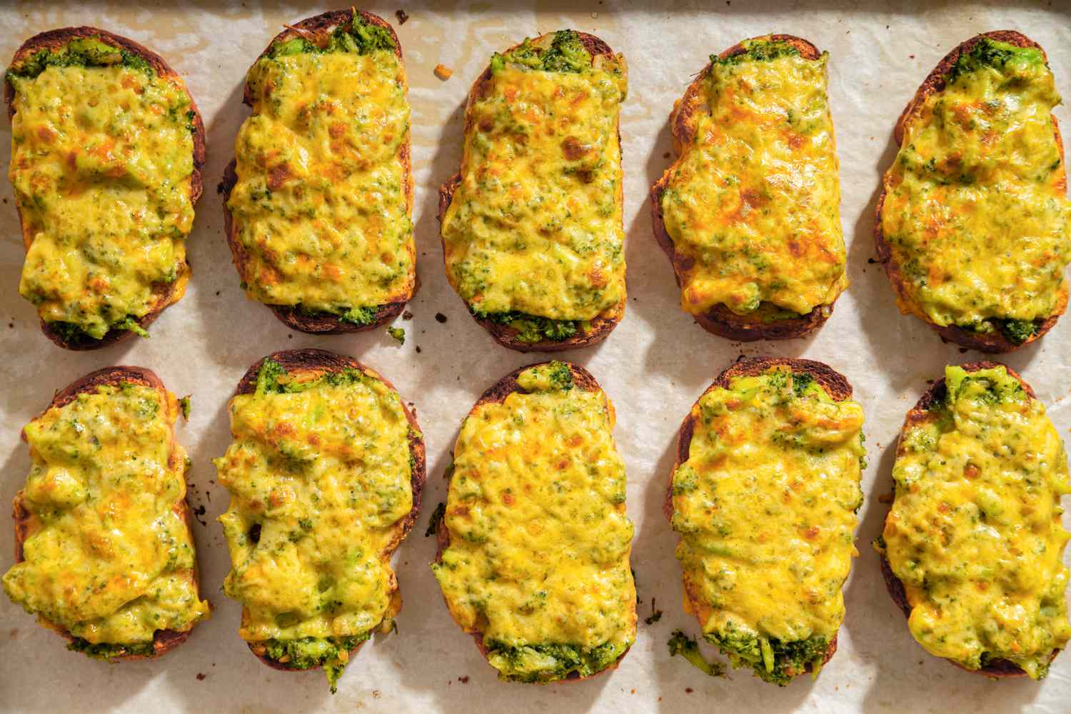 Broccoli cheddar toasts on a baking sheet