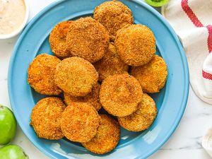 Overhead view of a plate of green tomatoes that have been breaded and fried.