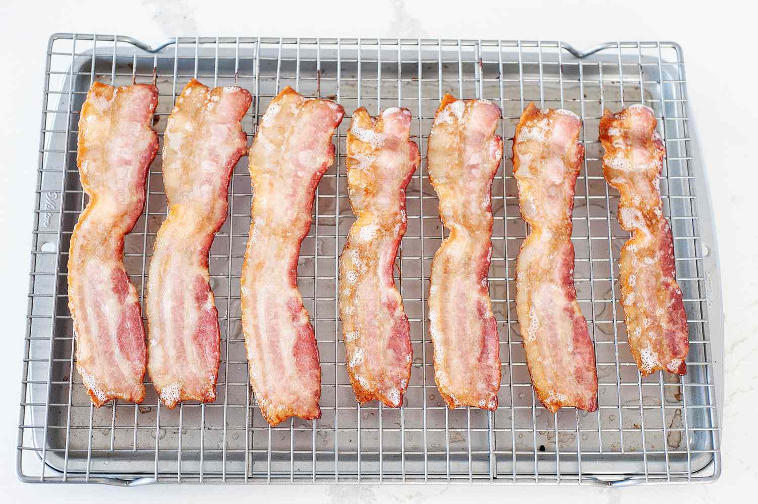 How to bake bacon in the oven on a cooling rack set over a sheet pan.