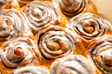 Cinnamon rolls topped with icing arranged closely together