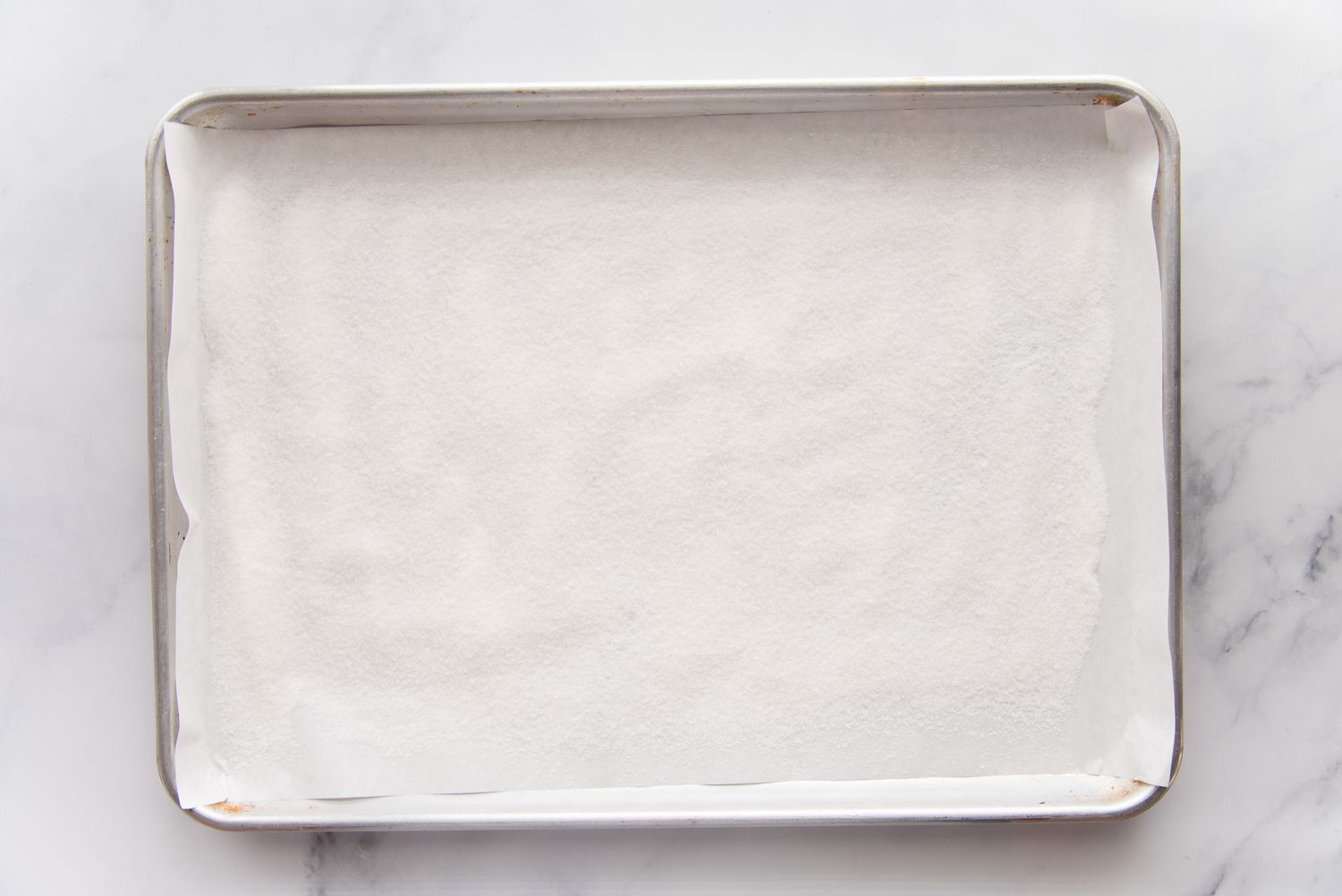 Line a baking sheet with parchment paper to make the best swiss roll cake recipe.