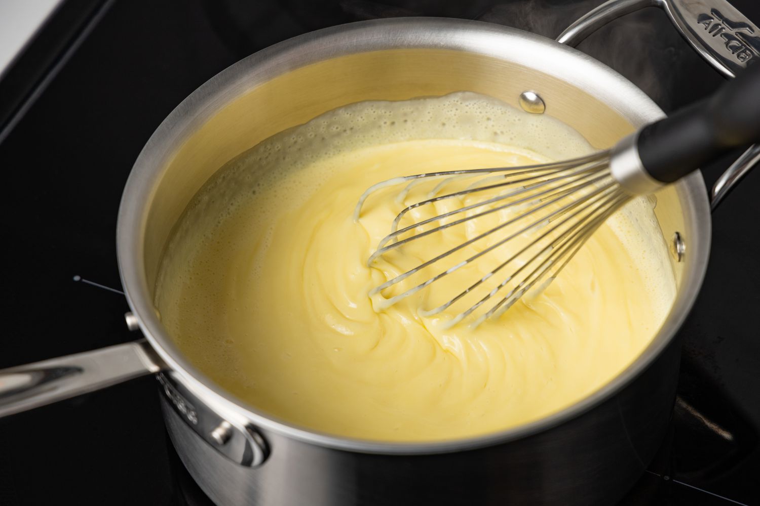 Whisk Pot of Vanilla Custard on Stove 