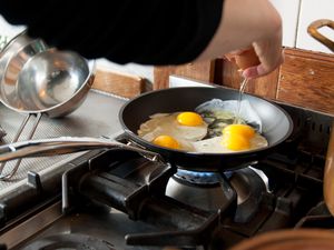 Person cooking eggs in a nonstick skillet