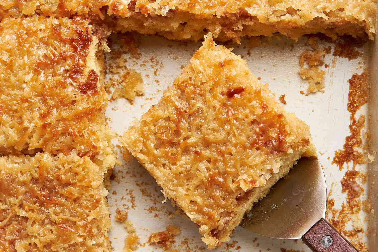 Lazy daisy cake slice on a spatula in a pan with more cake