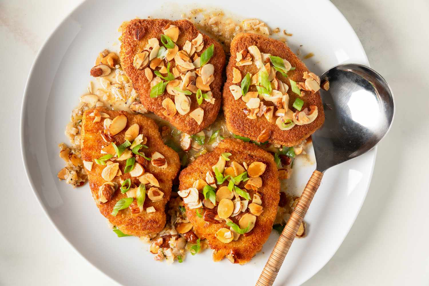 Easy Chicken Almondine on a platter with a large serving spoon