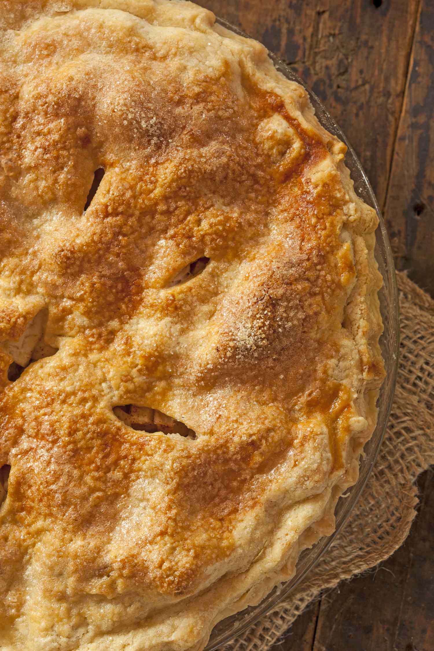 A baked apple pie on a rustic wooden surface