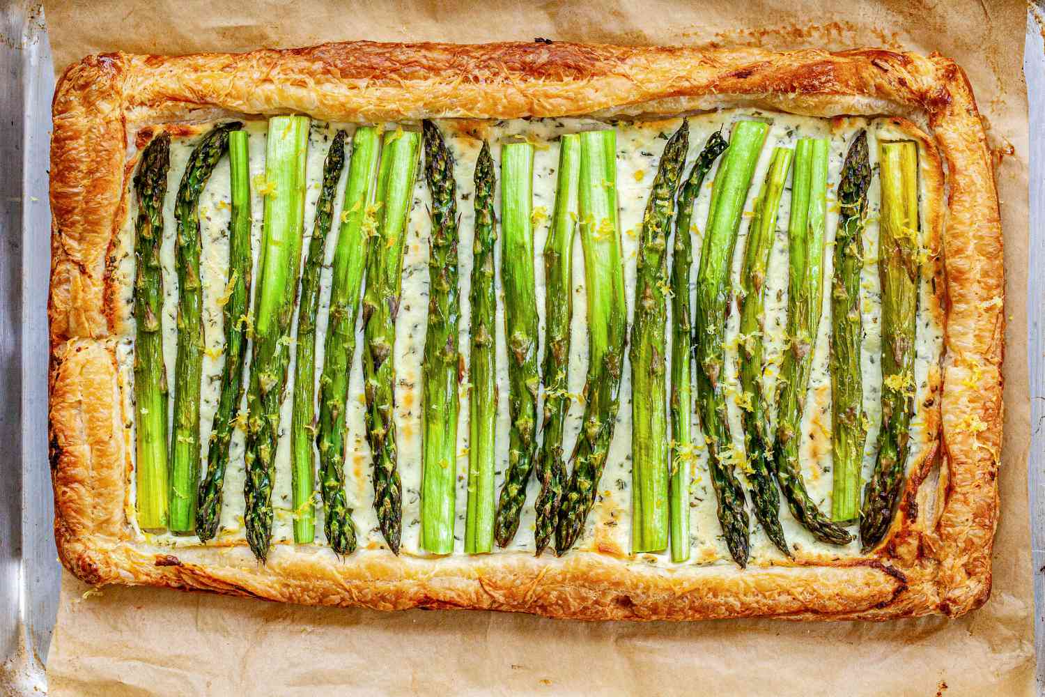 Asparagus Tart with Goat Cheese and Lemon baked and on a piece of parchment paper.
