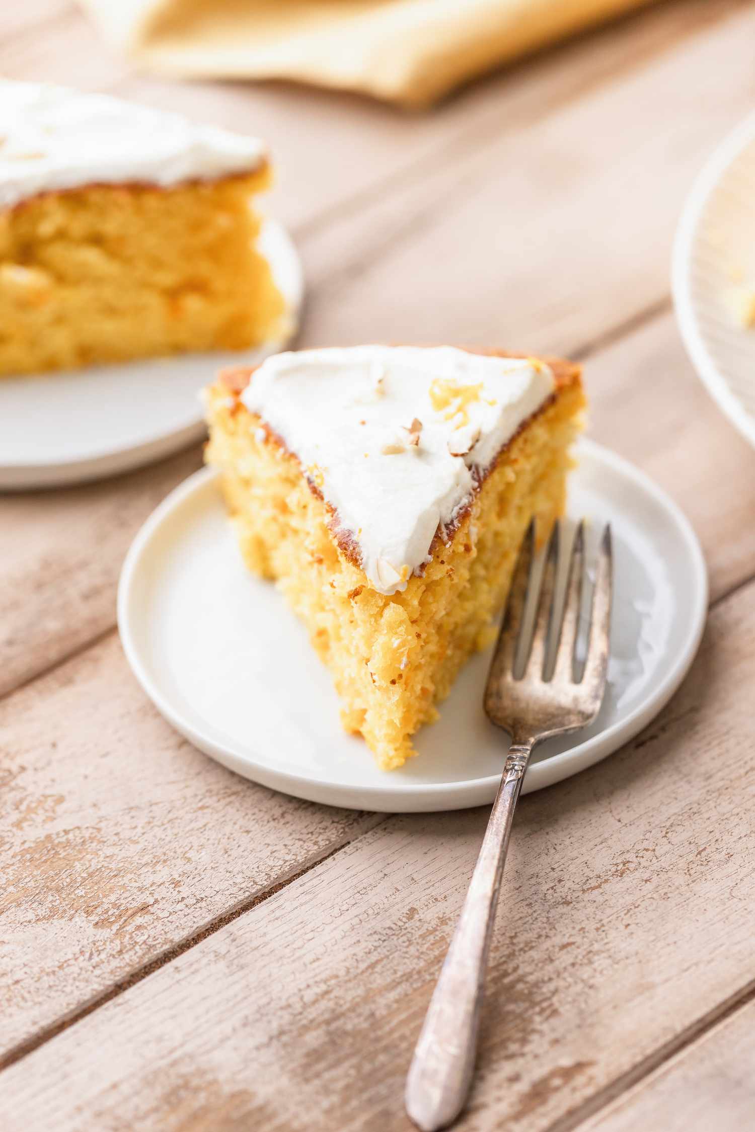 single slice of clementine cake on a small plate with a fork