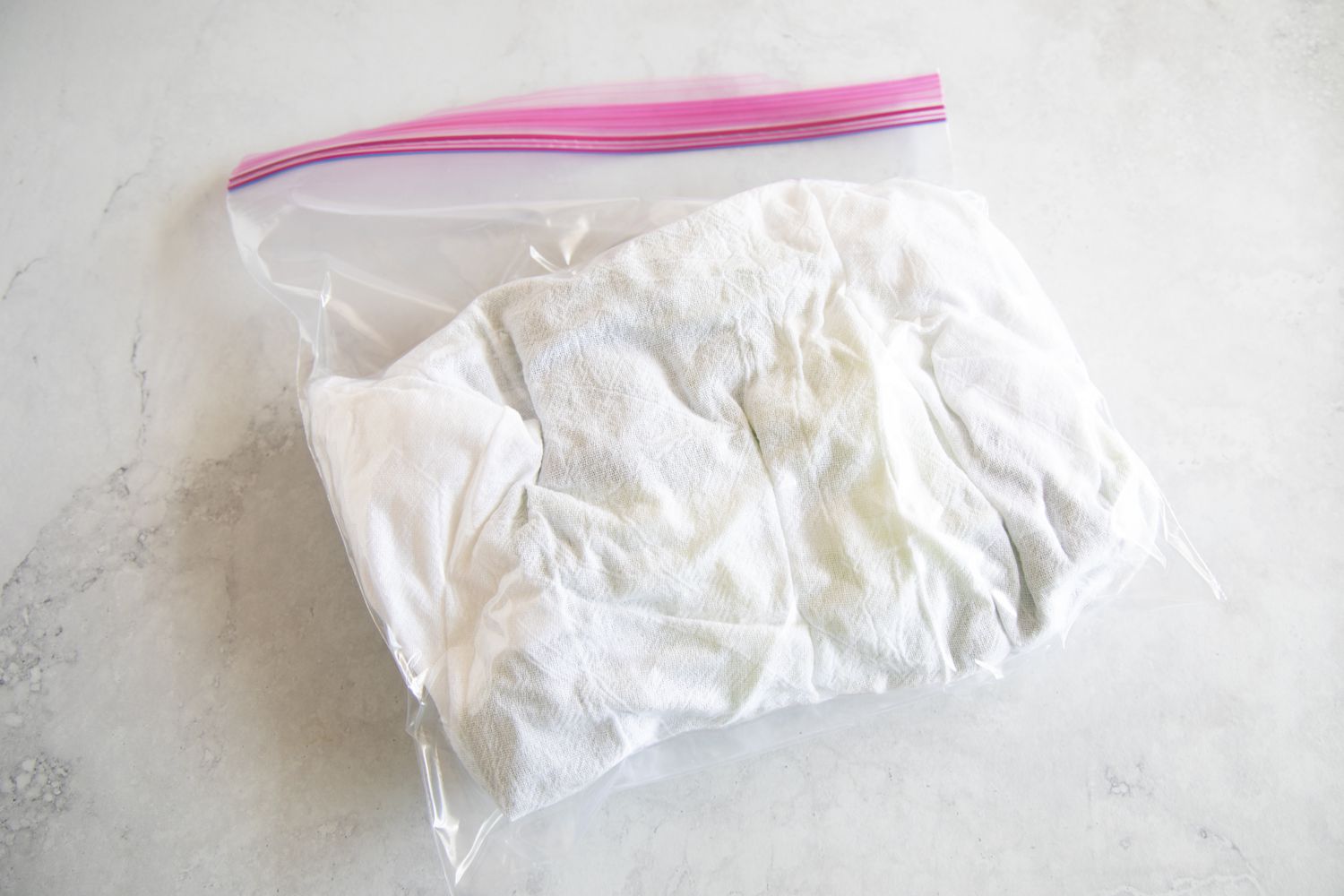 Lettuce wrapped in a flour sack towel and stored in a plastic ziptop bag