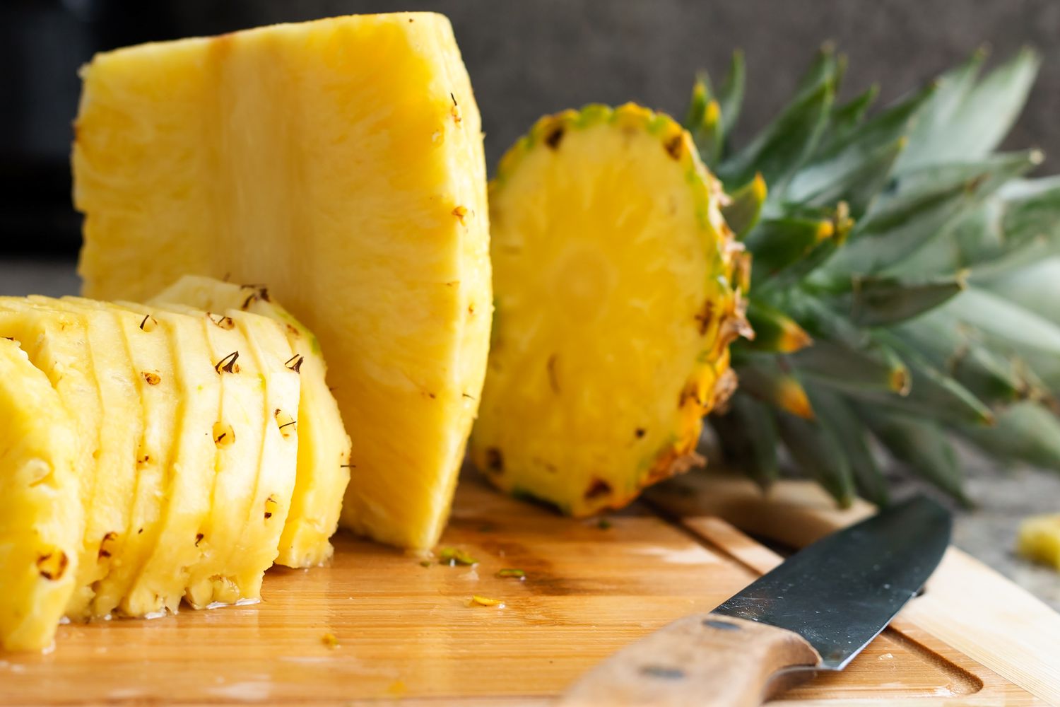 sliced pineapple on a wooden cutting board 