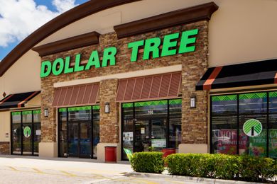 Storefront of a Dollar Tree location with signage and entrances visible, surrounded by shrubs and parking area