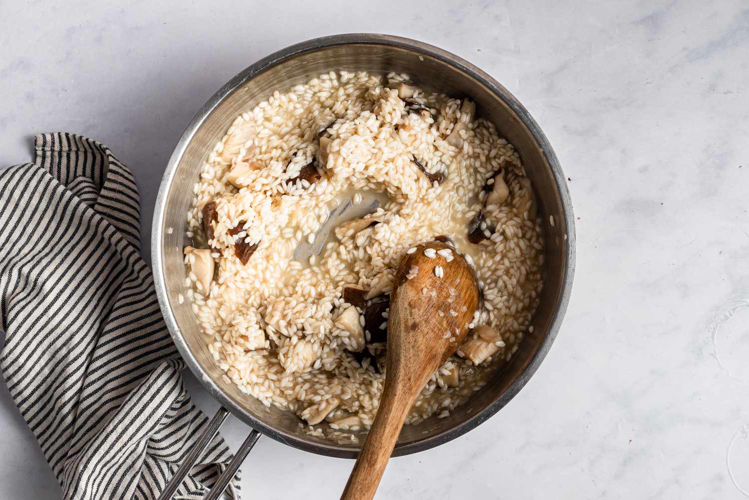A wooden spoon stirring the risotto mixture
